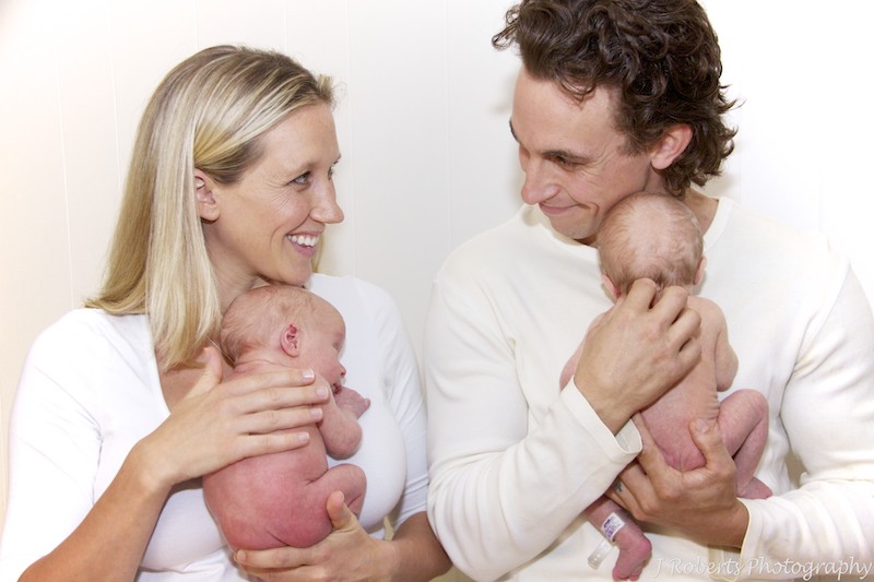 Mother and Father cuddling newborn twins - newborn baby photography sydney